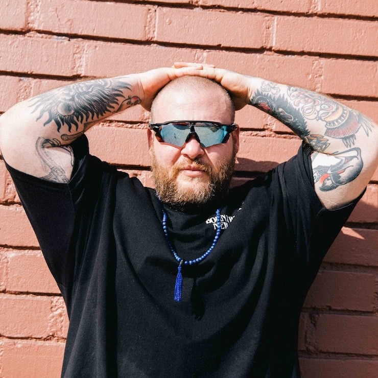 Press shot of Action Bronson with his hands on his head