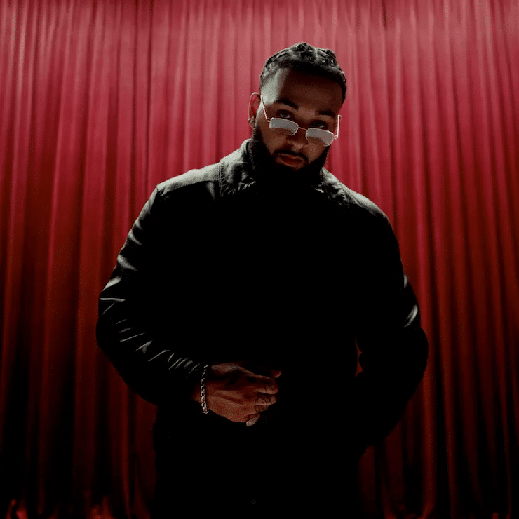Press shot of Isaiah Falls set against a backdrop of a red curtain
